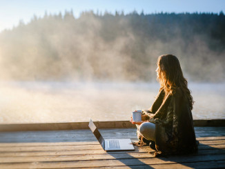 Woman Relaxing In Nature And Using Technology