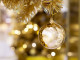 Beautiful Christmas golden ball hanging on pine tree with bokeh background