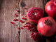 Some red juicy pomegranate, whole and broken, on dark rustic wooden table