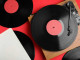 Modern player and vinyl records on red background, flat lay