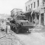 Η οδός Καποδιστρίου βομβαρδισμένη στις 18 Απριλίου 1941. Γερμανικά τανκς οδεύουν μέσα στην πόλη της Λαμίας.