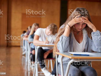 Anxious Teenage Student Sitting Examination In School Hall
