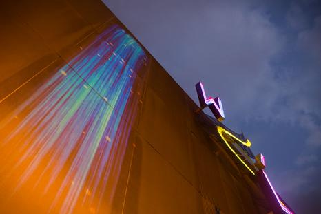 Andrea Polli, 2023, Φωτογραφία της καλλιτεχνικής εγκατάστασης Patricle Falls στο εξωτερικό του θεάτρου Wilma, Philadelphia. Τα χρώματα που εμφανίζονται στον τοίχο καθορίζονται από την ποσότητα και τους τύπους των σωματιδίων στον αέρα κάθε δεδομένη στιγμή.