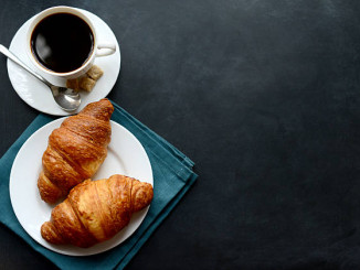 cup of coffee and croissants on black background