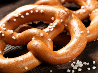 Fresh pretzels with sea salt close-up on  dark board background