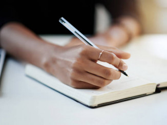 Closeup shot of a businesswoman writing in a notebook in an office
