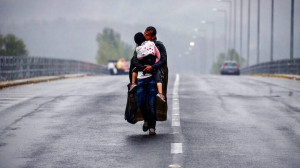 Πρόσφυγας κρατάει σφιχτά το παιδί του στη βροχή στα σύνορα Ελλάδας - Βόρειας Μακεδονίας. Η φωτογραφία βραβεύτηκε με Πούλιτζερ Πηγή:https://www.ethnos.gr/ellada/24721_giannis-mpehrakis-oi-deka-fotografies-toy-poy-tha-meinoyn-stin-istoria